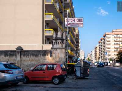 Circondato da cassonetti dell�immondizia e insegne...